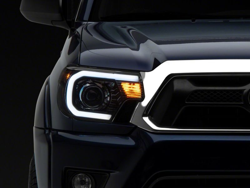 Raxiom 12-15 Toyota Tacoma Axial Series Projector Headlights w/ LED Bar- Black Housing (Clear Lens) Headlights Raxiom