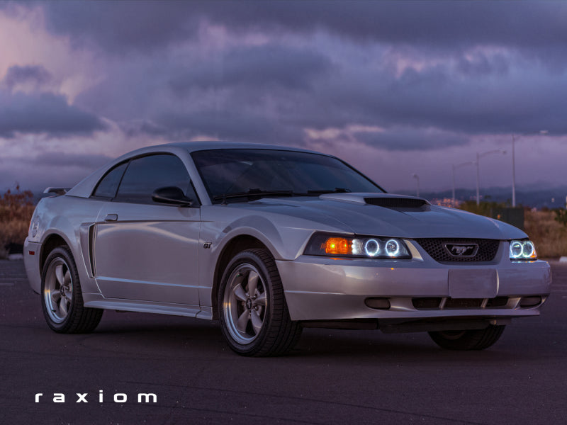 Raxiom 99-04 Ford Mustang Dual LED Halo Projector Headlights- Black Housing (Smoked Lens) Headlights Raxiom