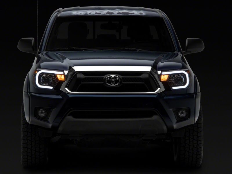 Raxiom 12-15 Toyota Tacoma Axial Projector Headlights w/ SEQL LED Bar- Black Housing (Clear Lens) Headlights Raxiom
