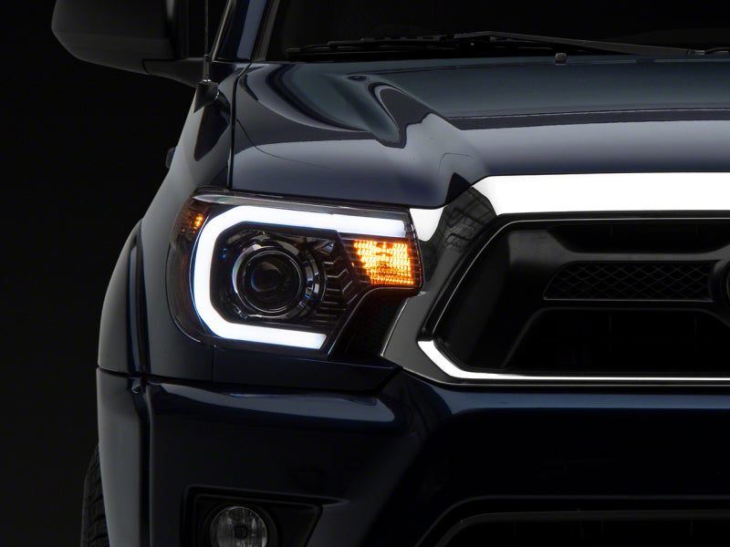 Raxiom 12-15 Toyota Tacoma Axial Projector Headlights w/ SEQL LED Bar- Black Housing (Clear Lens) Headlights Raxiom
