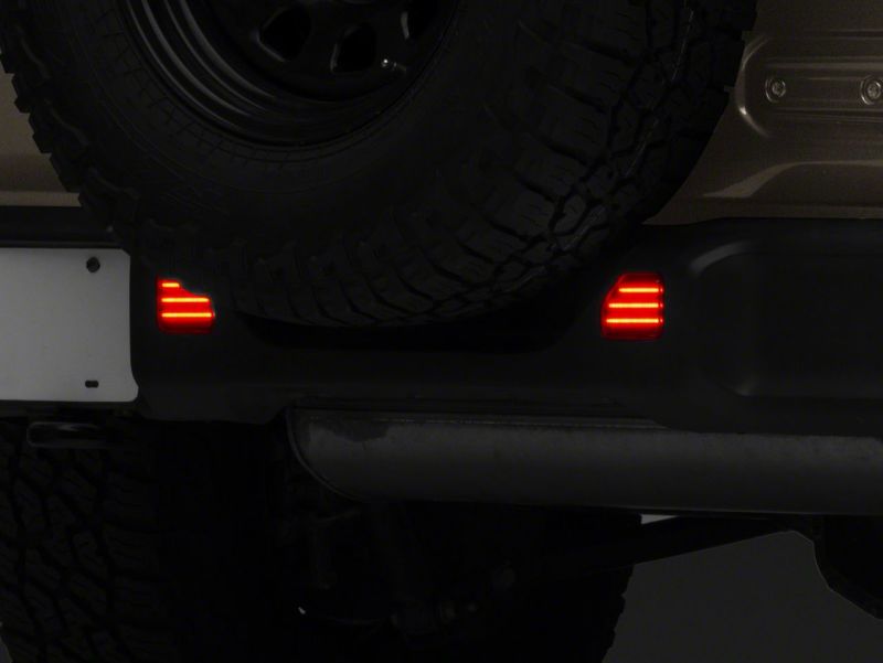 Raxiom 18-23 Jeep Wrangler JL Moab Rubicon Sahara Axial LED Rear Bumper Reflector Lights- Smoked Light Bars & Cubes Raxiom