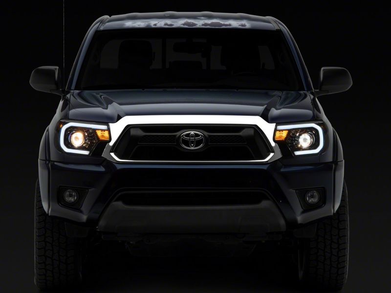Raxiom 12-15 Toyota Tacoma Axial Series Projector Headlights w/ LED Bar- Black Housing (Clear Lens) Headlights Raxiom