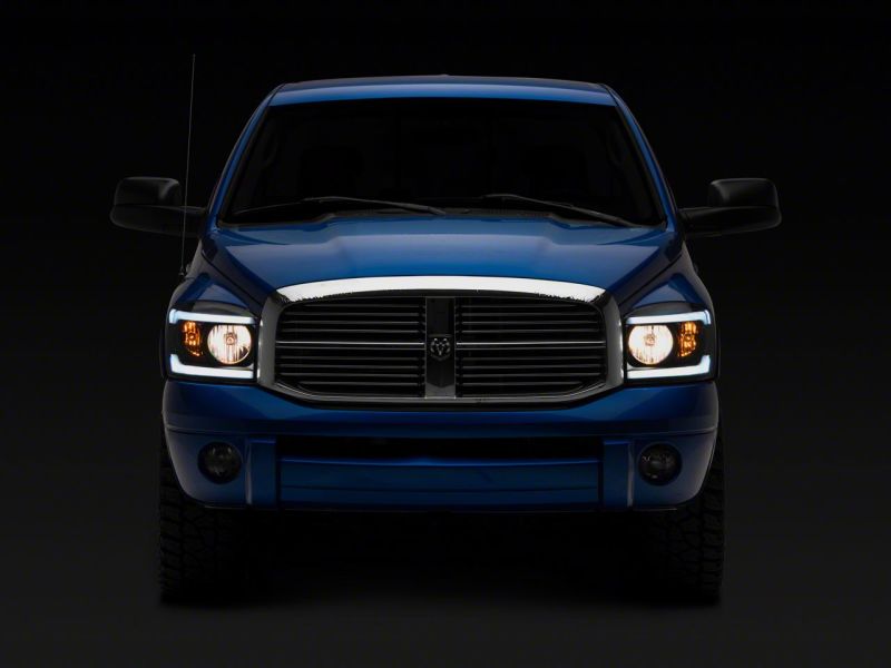 Raxiom 06-09 Dodge RAM 1500/2500/3500 Axial Headlights w/ SEQL LED Bar- Blk Housing (Clear Lens) Headlights Raxiom