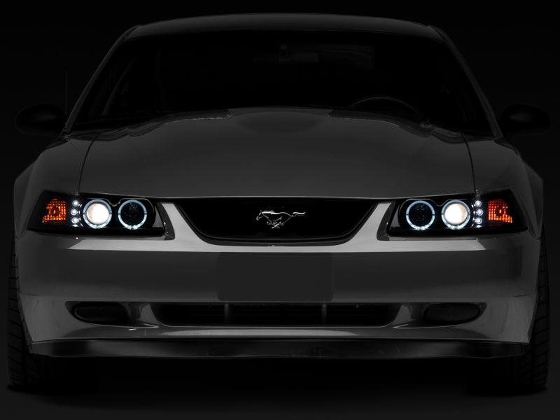 Raxiom 99-04 Ford Mustang Dual LED Halo Projector Headlights- Black Housing (Smoked Lens) Headlights Raxiom